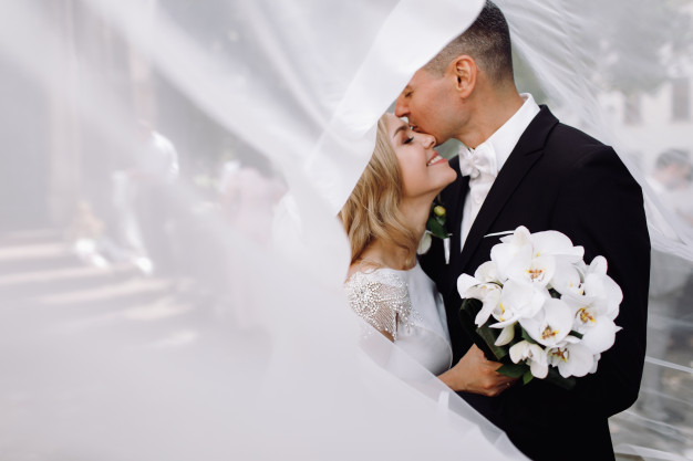 groom black tuxedo hugs tender stunning bride while they stand 8353 8050 - Casamento Barato, Lindo e Inesquecível